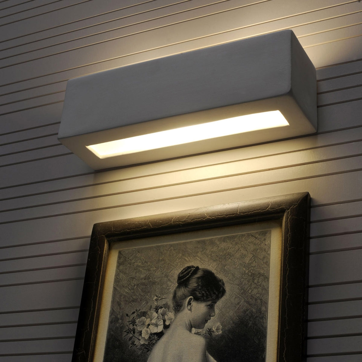 VEGA ceramic wall sconce by Sollux Lighting mounted above framed artwork providing warm indoor lighting