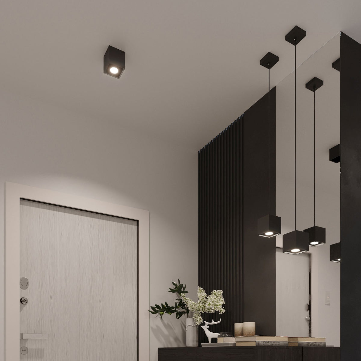 Modern black cube wall light mounted on ceiling illuminating a minimalist entryway with black and white decor