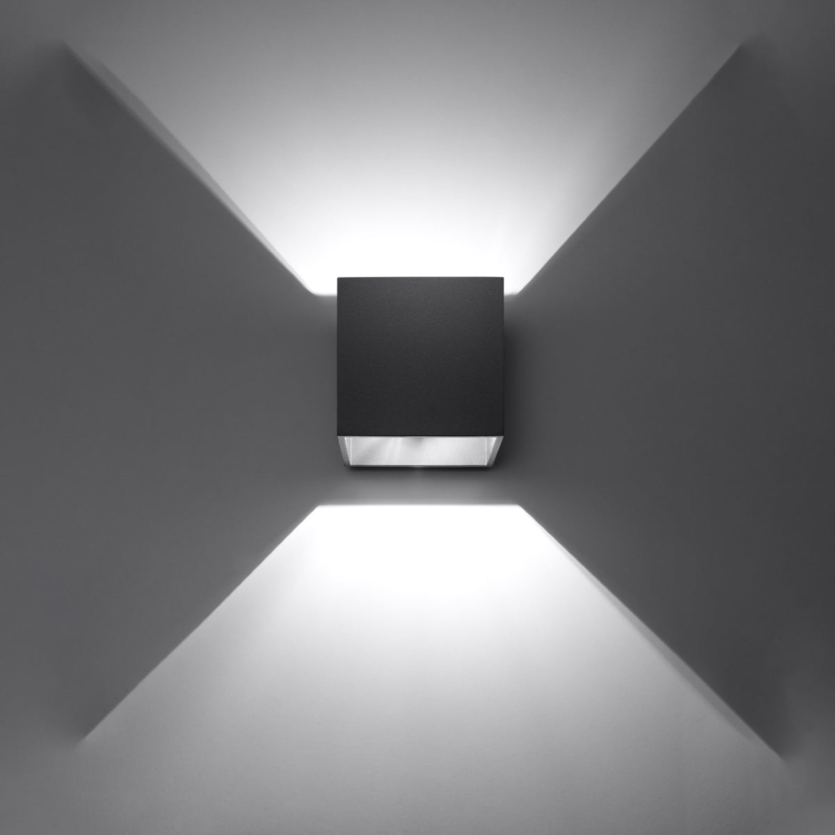 Modern black cube wall light by Sollux Lighting casting symmetrical white light patterns on gray wall