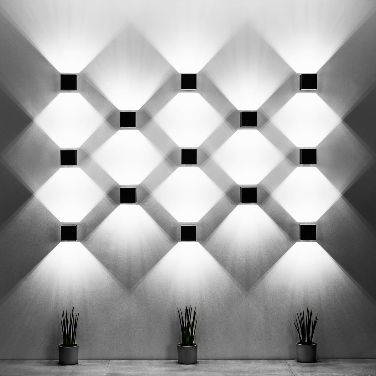 Modern cube white wall lamp set by Sollux Lighting creating geometric light patterns on a white wall